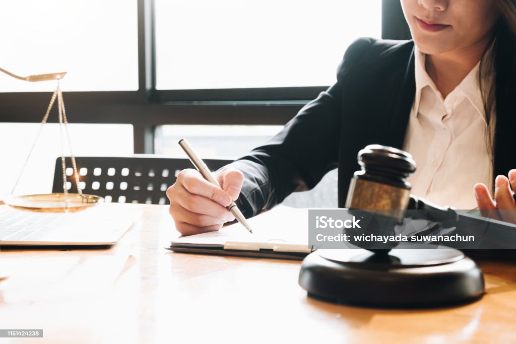 Business woman and lawyers discussing contract papers with brass scale on wooden desk in office. Law, legal services, advice, Justice concept. Lawyer Stock Photo