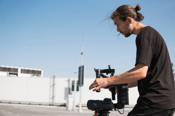 istock Professional videographer holding camera on 3-axis gimbal. Videographer using steadicam. Pro equipment helps to make high quality video without shaking. 1151424910