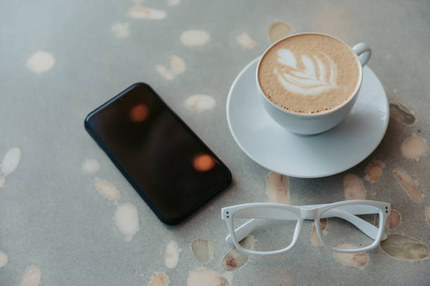 istock Cup of coffee, glasses and smartphone lying on table 1151427015