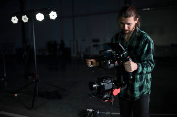 istock Professional videographer holding camera on 3-axis gimbal. Videographer using steadicam. Pro equipment helps to make high quality video without shaking. 1151427289