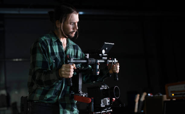 istock Professional videographer holding camera on 3-axis gimbal. Videographer using steadicam. Pro equipment helps to make high quality video without shaking. 1151427305