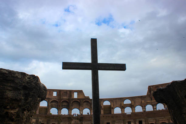 istock Cross in colloseum, cloudy sky 1151427567