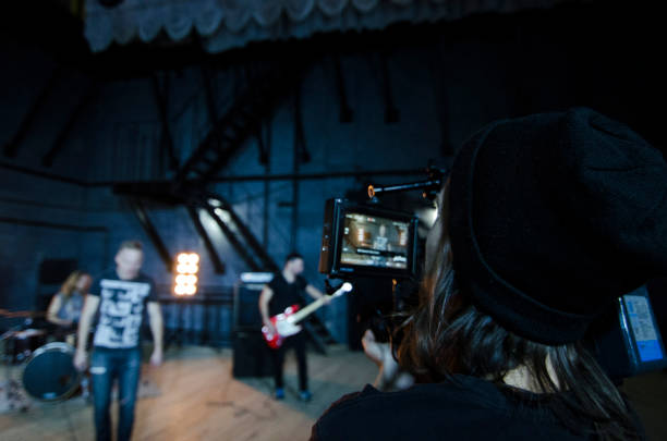 istock Professional videographer using cinema digital video camera for filming a music video. 1151428281