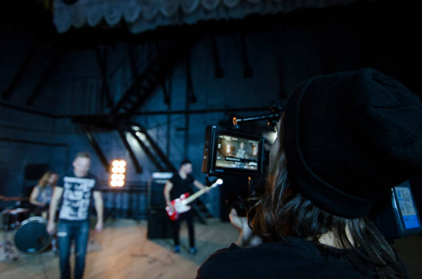 Professional videographer using cinema digital video camera for filming a music video. stock photo