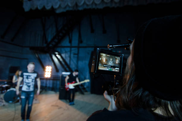 Professional videographer using cinema digital video camera for filming a music video