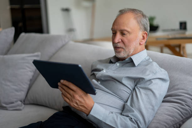 istock Senior man working online at home on a digital tablet 1151429553