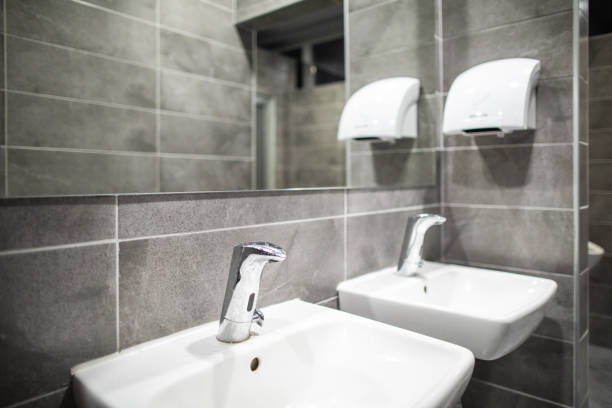 Public restroom Sinks in public restroom, hand dryer, clean toilet, no people restaurant mirror stock pictures, royalty-free photos & images