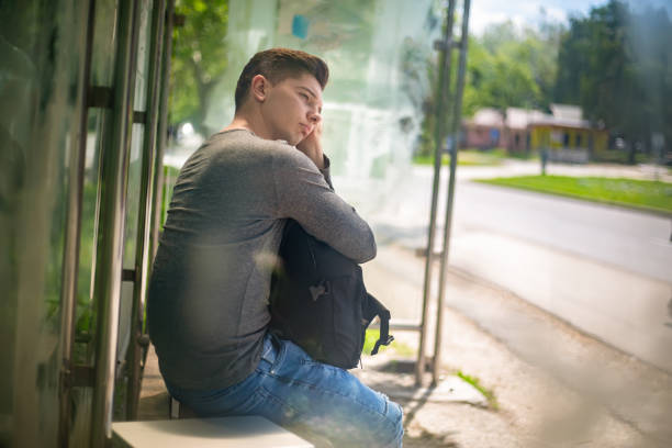 With his hands clasped and looking down, the teenage boy thinks through the decision he has to make.