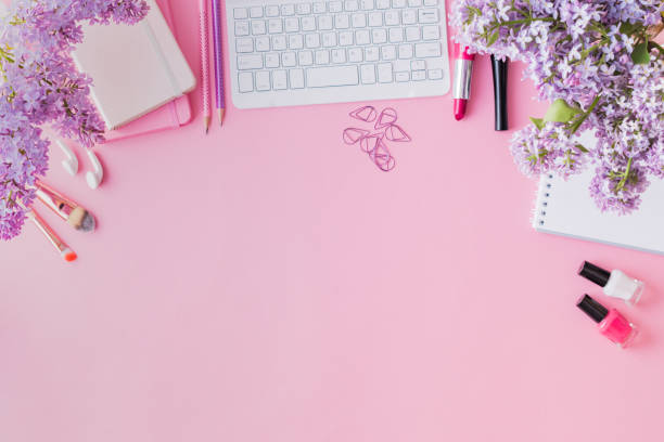 istock Flat lay blogger or freelancer workspace with a notebook, keyboard and branches of lilac on a pink background 1151433558