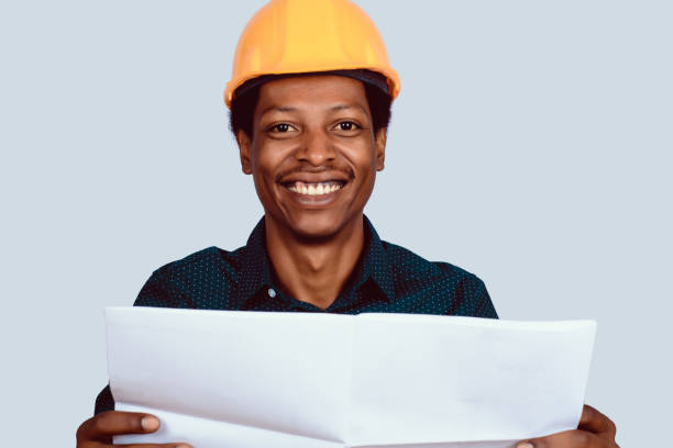 istock Afro american architect in hard hat with blueprint. 1151433803