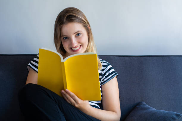 istock Woman reading a book at home 1151433821