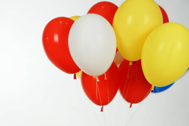 istock colorful balloons and hand on isolated white background. 1151434180