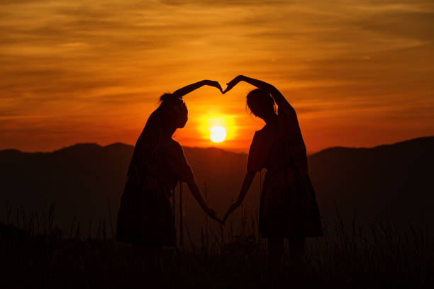 In beautiful sunlight. Majestic view. Two little girls have fun outdoors on the field at summer.