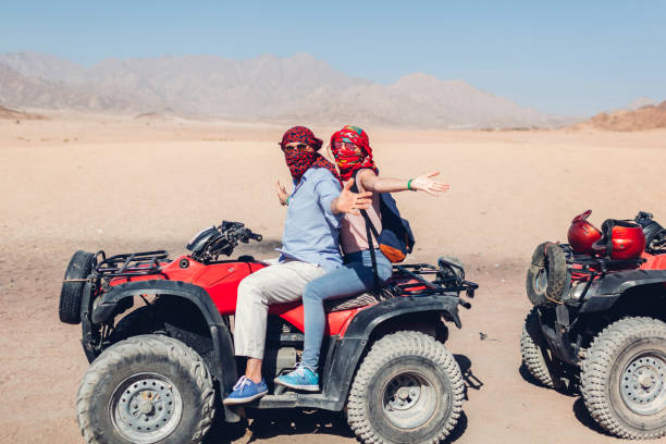 Man and his daughter driving quad bike in Sinai desert. Happy family having fun during summer vacation Man and his daughter driving quad bike in Sinai desert. Happy family having fun during summer vacation in Egypt desert safari stock pictures, royalty-free photos & images
