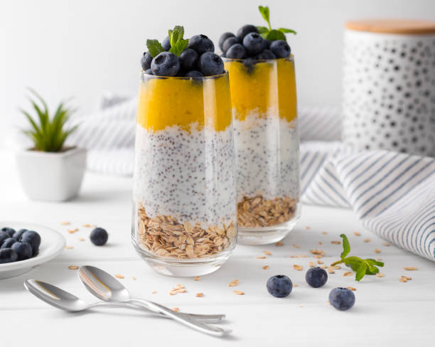 istock Two Glasses of chia pudding with blueberries, mango mousse and oat granola on the kitchen table. 1151438849