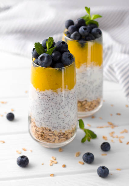 istock Two Glasses of chia pudding with blueberries, mango mousse and oat granola on the kitchen table. 1151438850