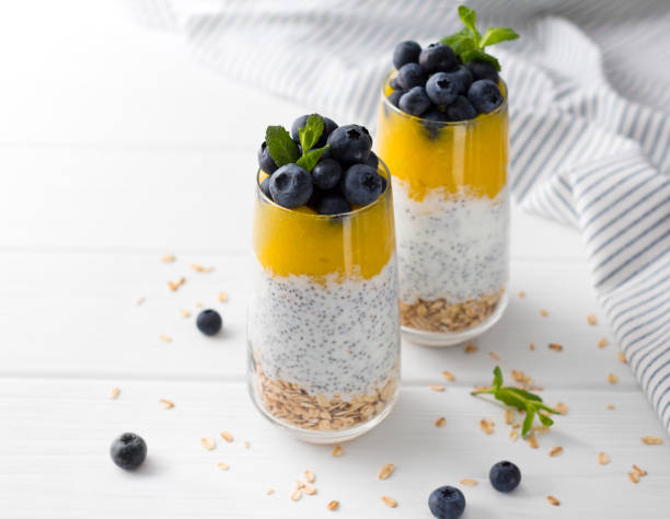 istock Two Glasses of chia pudding with blueberries, mango mousse and oat granola on the kitchen table. 1151438852