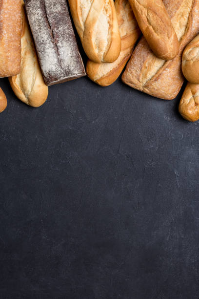 istock Fresh bread on black board, top view with free space 1151445888