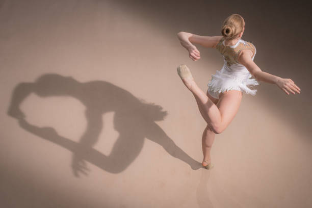 Modern ballet dancer High angle view of a modern ballet dancer and her shadow, copy space. ballerina shadow stock pictures, royalty-free photos & images