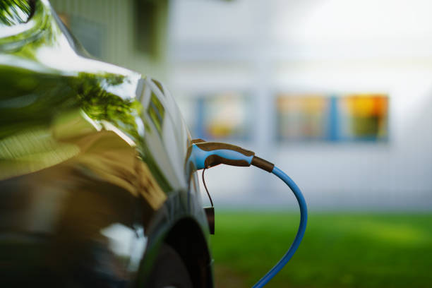 Electric Car is charging in front of house Electric Car is charging in front of house electric car stock pictures, royalty-free photos & images