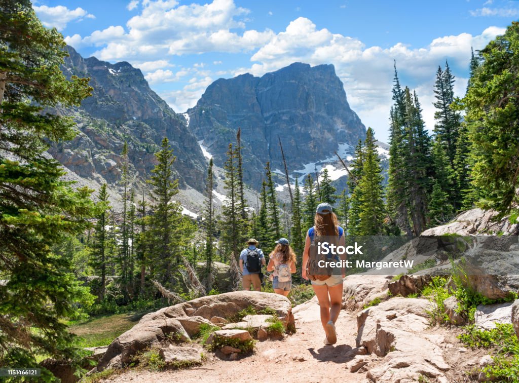 Family hiking on summer vacation in Colorado mountains. Family on summer vacation hiking trip in the mountains.People hiking on Emerald Lake Trail. People exploring Colorado mountains. Estes Park, Rocky Mountains National Park, Colorado, USA. Hiking Stock Photo
