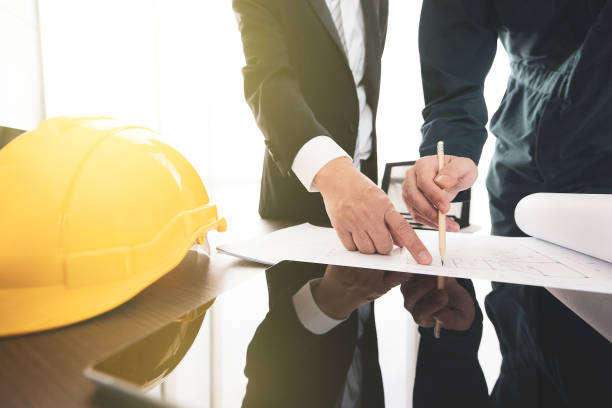 istock Businessman and engineer reviewing plan design 1151466238