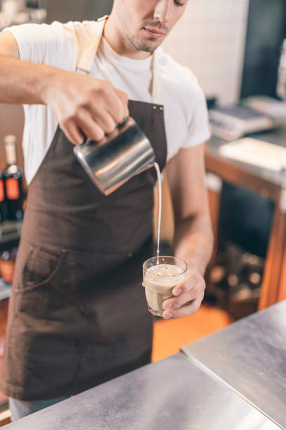 istock Concentrated barista making coffee with milk at work 1151466780