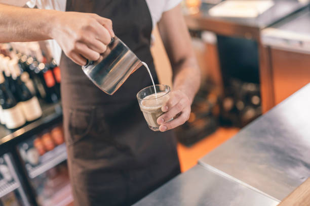 istock Barista holding milk pitcher while making coffee with milk 1151466786