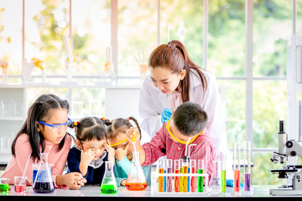 istock In lab, boy drop something into orange tube. 1151467495