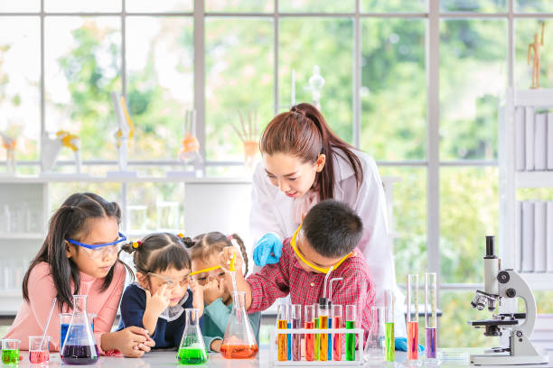 istock In lab, boy drop something into orange tube. 1151467535