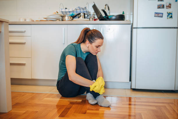 istock Tired woman sitting on the kitchen floor 1151470222