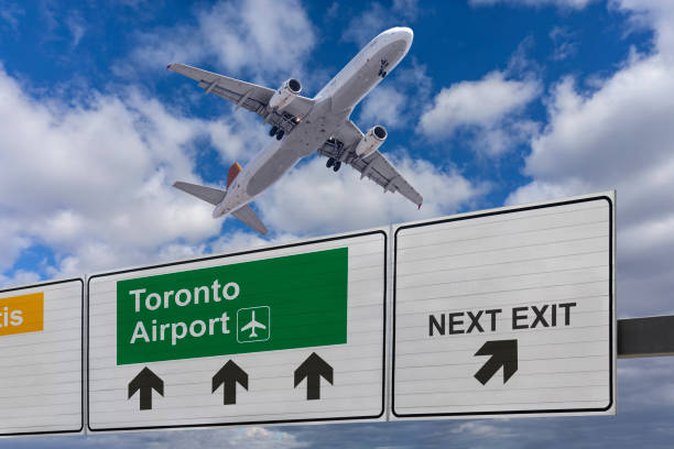 Road sign indicating the direction of Toronto airport and a plane that just got up. Road sign indicating the direction of Toronto airport and a plane that just got up. landing craft stock pictures, royalty-free photos & images