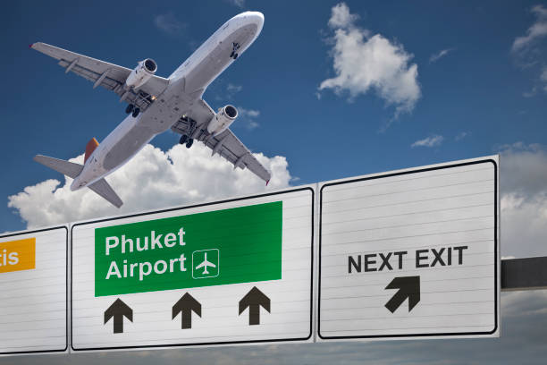 Road sign indicating the direction of Phuket airport and a plane that just got up. Road sign indicating the direction of Phuket airport and a plane that just got up. landing craft stock pictures, royalty-free photos & images