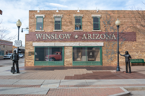 Winslow, Arizona, United States of America - January 4, 2017. Standin' On The Corner Park in Winslow, AZ, with statue, historic building, murals, Route 66 sign and cars.