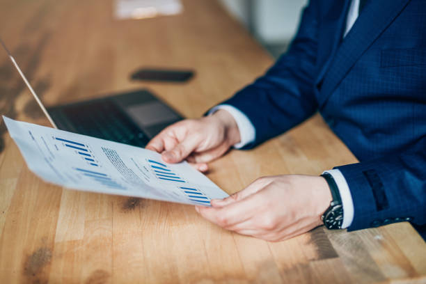 istock Businessman reading document at desk in office 1151475851