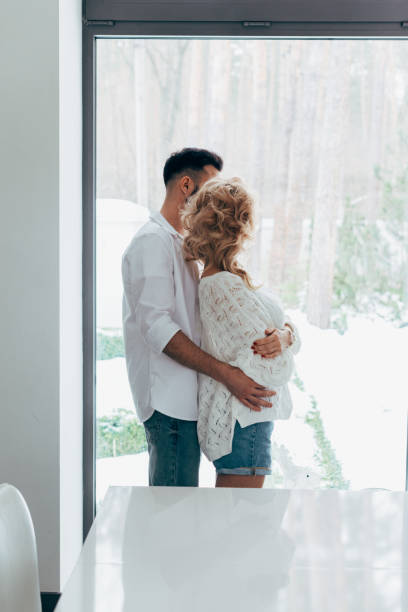 istock Romantic couple embracing and looking at window 1151479784