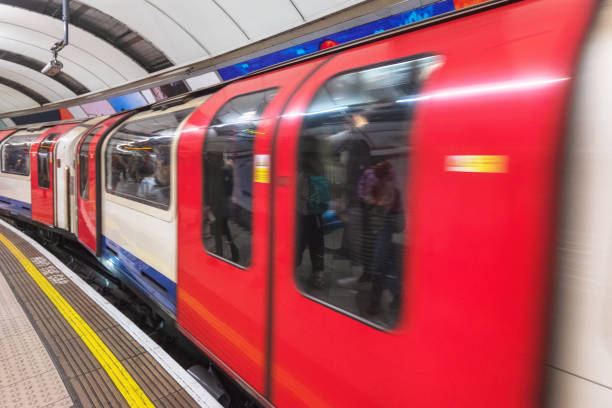 London, United Kingdom - May 13, 2019: London tube platform edge. Painted warning on the floor. Train passing by .