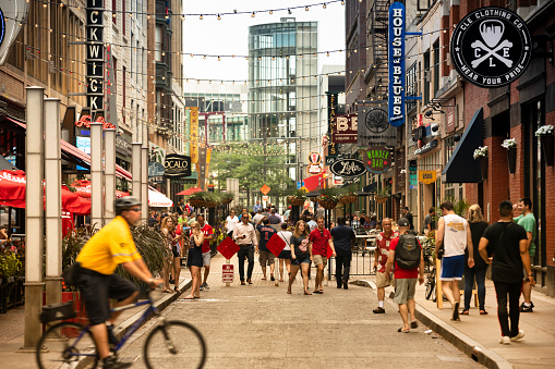 Cleveland, Ohio, USA - June 18, 2018: People walk by bars and restaurants along busy 4th street in the downtown core of Cleveland Ohio USA