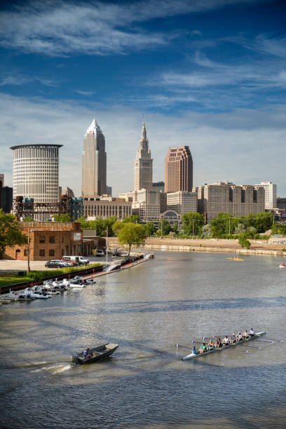 Downtown Cleveland city skyline in Ohio USA Cleveland, Ohio, USA - June 19, 2018:  Rowing team trains on the Cuyahoga river by the downtown skyline view of Cleveland Ohio USA cuyahoga river photos stock pictures, royalty-free photos & images
