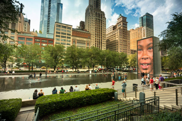 Chicago, Illinois, USA - September 20, 2018:  People and children play in the Crown Fountain in Millennium Park during a summer day in downtown Chicago Illinois USA.  Crown Fountain is a public sculpture with a pair of 50-ft. LED towers and a reflecting pool, by Jaume Plensa