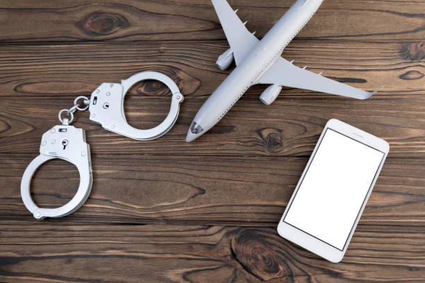 istock handcuffs, airplane, smartphone on a wooden background. 1151483815