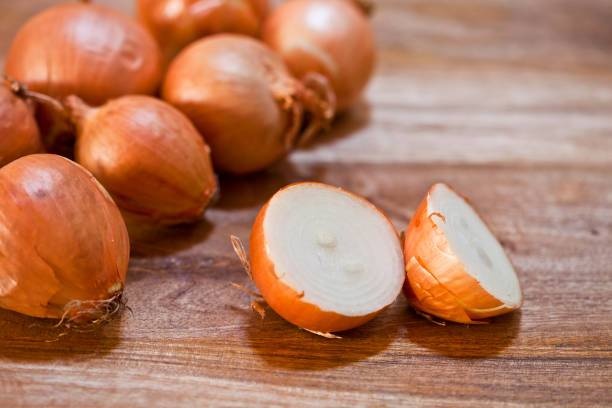 istock Organic fresh  onions heap closeup on rustic wooden table background. 1151485603