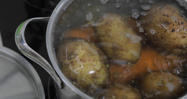 istock Hot boiling pan with vegetables potatoes and carrots. Cooking in kitchen 1151487390