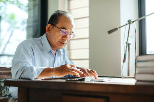 istock Senior Taiwanese man checking bills 1151493944