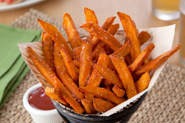 Sweet Potato Fries close up a basket of sweet potato fries sweet potato french fries stock pictures, royalty-free photos & images