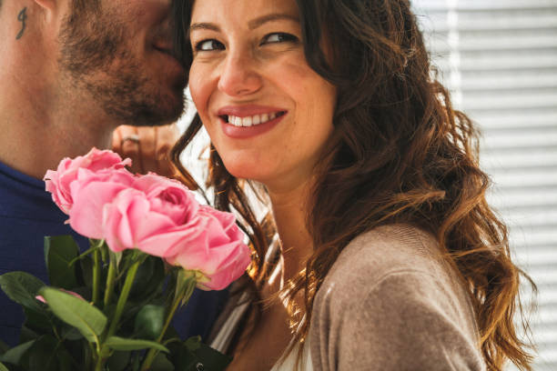 istock Beautiful couple is hugging and smiling, holding roses 1151496788