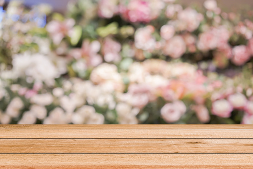 abstract blurred group of freshness blossom flowers  background with wood tabletop perspective for show , promote  product on display image