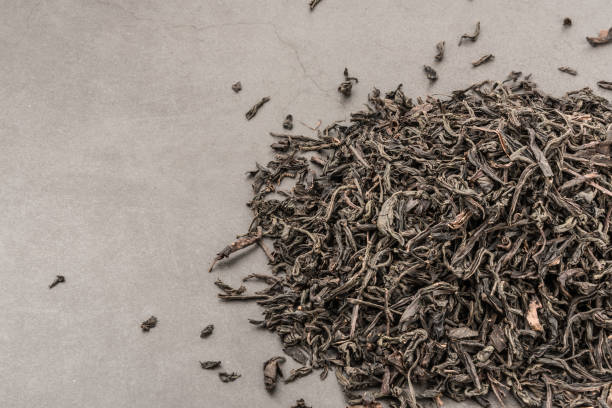 istock Dried tea is poured scattered on a grey textured background. 1151527240