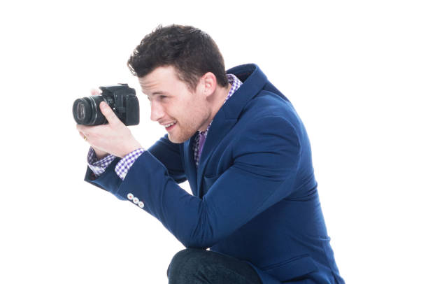 istock Side view of handsome man crouching while holding DSLR camera 1151532800