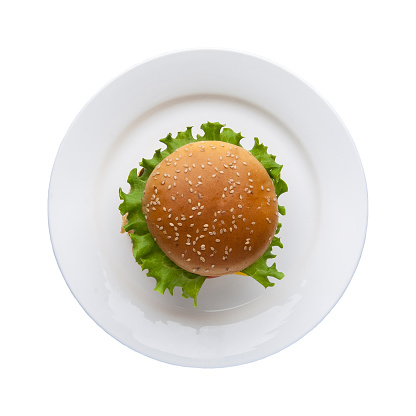 hamburger with lettuce in a plate on a white background, top view